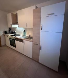 爱尔福特Schöne helle Ferienwohnung 64qm mit Kingsize Bett, Smart-TV, Wlan und sehr ruhige Lage的厨房配有白色橱柜和白色冰箱。