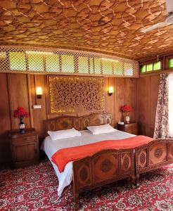 斯利那加Lily Of The World Houseboat的一间卧室设有一张带木制天花板的大床
