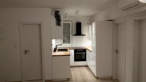 斯普利特卡Mira的厨房配有白色橱柜和炉灶烤箱。