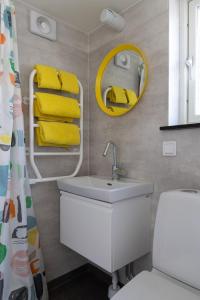 瑟尔沃斯堡Havsstugan的浴室设有水槽、镜子和黄色毛巾