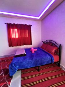 廷吉尔auberge restaurant tizgui的一间卧室配有一张蓝色的床,上面有粉红色玩具