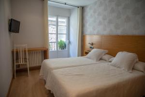 桑亨霍Hotel Casa Román的卧室设有一张白色大床和一扇窗户。