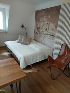 维尔茨堡stilvolle Wohnung direkt in der City的一间卧室配有一张床、一把椅子和一张桌子