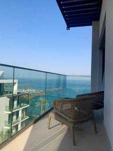 富查伊拉Ocean Mountain View Apartment at The Address Fujairah的海景阳台上的长凳