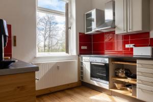MügelnZeitreise: Wohnen im Herrenhaus genau zw. L u. DD的厨房的墙壁上铺有红色瓷砖,设有窗户。
