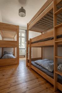 MügelnZeitreise: Wohnen im Herrenhaus genau zw. L u. DD的铺有木地板的客房内配有两张双层床。