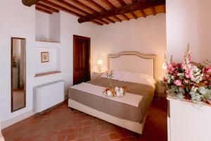 皮恩扎博尔戈圣特安布罗吉奥度假村的一间卧室,床上放着鲜花