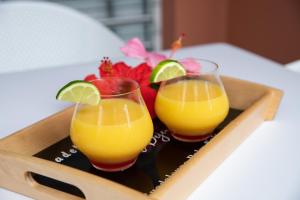 圣弗朗索瓦Hôtel Guadeloupe Palm Suites的托盘上放两杯橙汁