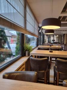维特兹博尔汽车旅馆的餐厅设有木桌、椅子和大窗户。