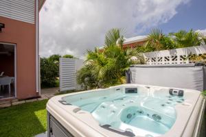 圣弗朗索瓦Hôtel Guadeloupe Palm Suites的房屋后院的热水浴池