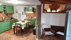 米斯泰尔比安科House dependance Belvedere的厨房配有绿色橱柜和桌椅