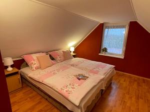 欧罗什哈佐Napfény nyaraló的一间卧室配有一张带粉色床单的床和一扇窗户。