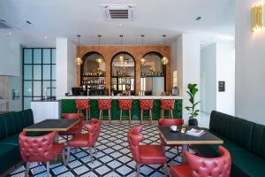 罗德镇Naillac Boutique Hotel的一间设有红色桌椅的餐厅和一间酒吧