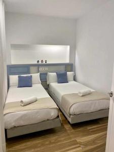 哈恩VELALMA DÚPLEX centro histórico的客房配有两张带蓝色枕头的床。