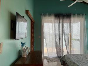 巴斯蒂门多斯Casita Azul的一间卧室设有绿色的墙壁、一张床和窗户