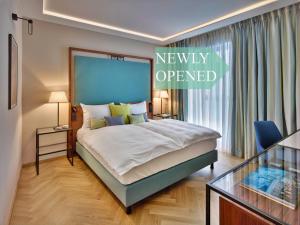 布达佩斯EST Grand Hotel Savoy的一间卧室配有一张新开的标志的床