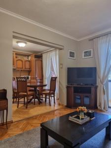 地拉那Tirana Center Cozy Apartment的一间带桌子的客厅和一间餐厅