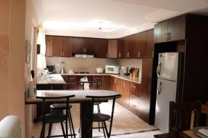 昆卡Cozy and Spacious Home with Incredible Location的厨房配有木制橱柜、桌子和冰箱。