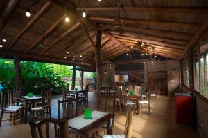 伊瓜苏港拉阿尔德德拉瑟尔瓦旅馆的餐厅设有木桌和椅子及灯