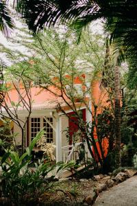 德赛Caraib'Bay Hotel的一座白色和橙色的房子,前面有树木