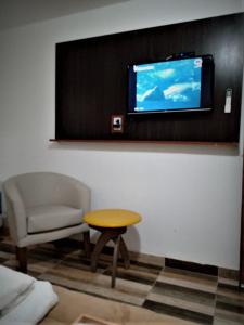 菲安巴拉Complejo San Antonio的客厅配有椅子、桌子和电视