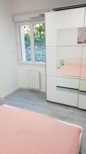 马赛gite sous l'olivier的配有粉红色的床和镜子的房间