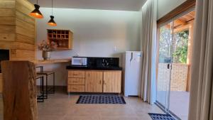 瓦尔任博尼塔POUSADA JURERE DA CANASTRA的厨房配有冰箱和带微波炉的桌子。