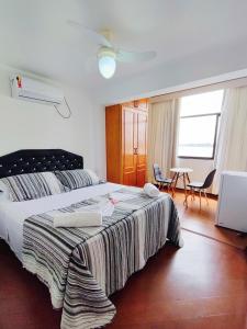 里约热内卢Marambaia Mar的卧室配有一张床和一张桌子及椅子