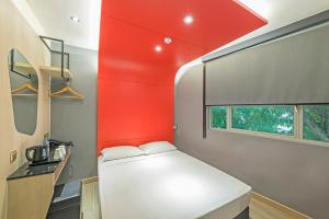 新加坡Hotel 81 Lavender的小房间设有一张床和红色的墙壁