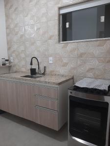 卡波布里奥Apartamento Confortável Perto da Praia的厨房配有水槽和炉灶。
