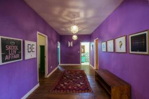 坎古The Chillhouse Canggu by BVR Bali Holiday Rentals的走廊上设有紫色墙壁、长凳和地毯
