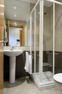 哈罗紫鞋旅游公寓的一间带玻璃淋浴和水槽的浴室