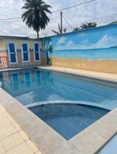 雅温得Primeshare Luxury Apartments Ebang - Swimming Pool, Snack, Sports, & Tech Center的一个带海滩壁画的游泳池
