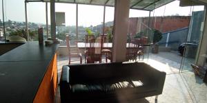 塞拉内格拉RECANTO K9 - SERRA NEGRA SP. No verão e no inverno的阳台设有带桌椅的客厅