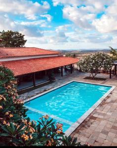 格拉瓦塔Flat aconchegante em Hotel Fazenda Monte Castelo的房屋前游泳池的图像
