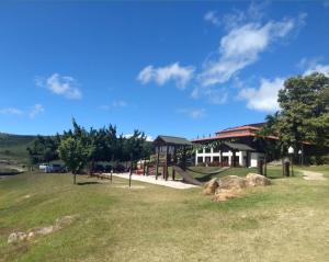 格拉瓦塔Flat aconchegante em Hotel Fazenda Monte Castelo的公园,在田间中间建有建筑物