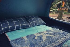 槟知Ecoco Homestay Mekong的帐篷内的一张床位,上面有毯子