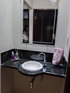 皮拉西卡巴Espacin Maricris-28 min. Thermas Sao Pedro的浴室的柜台设有水槽和镜子