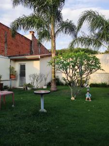 皮拉西卡巴Espacin Maricris-28 min. Thermas Sao Pedro的坐在院子里的孩子,有桌子和棕榈树