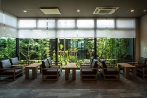 四国中央市Hotel Route Inn Shikoku Chuo的大堂设有桌椅和大窗户。