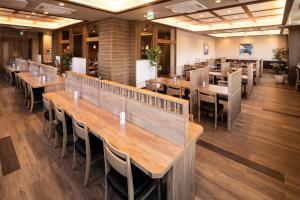 四国中央市Hotel Route Inn Shikoku Chuo的用餐室配有木桌和椅子