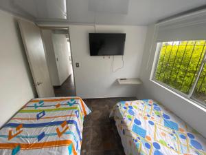 NeiraApartamento tipo finca lleno de vida y elegancia.的卧室配有一张床,墙上配有电视。