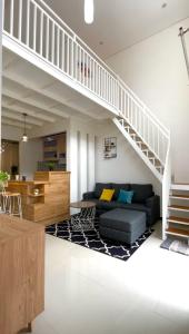 巴图Villa Tiga Dara Batu的带沙发和楼梯的客厅