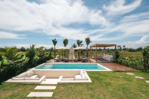海神庙Botanique Villa & Studio的一个带白色家具的室外游泳池和别墅