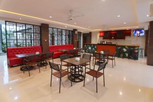 TjakranegaraLombok Mayura Hotel的一间带桌椅和红色摊位的餐厅