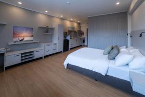 苏瓦Toorak Central的卧室配有一张白色大床和一台平面电视。