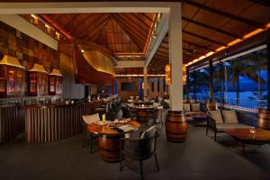 瓦亚纳德Taj Wayanad Resort & Spa, Kerala的一间带桌椅的餐厅和一间酒吧