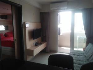 三宝垄Mg Suite 1bedroom Apartment by Just Inn Management的客房设有床、电视和窗户。