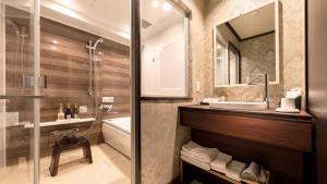 广岛Hiroshima Grand Intelligent Hotel的一间带水槽、浴缸和淋浴的浴室