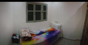 Bel Aroussiغرفة فردية خاصة للاناث的一间卧室配有彩虹床和窗户。